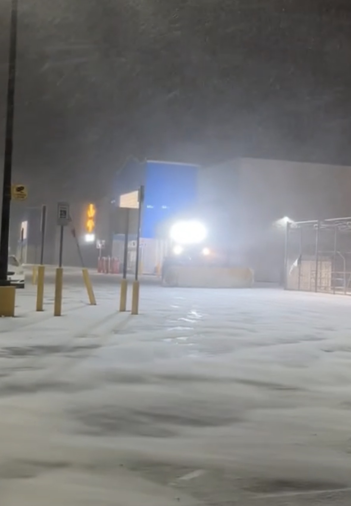 Swift plow truck working a commercial parking lot during heavy snowfall