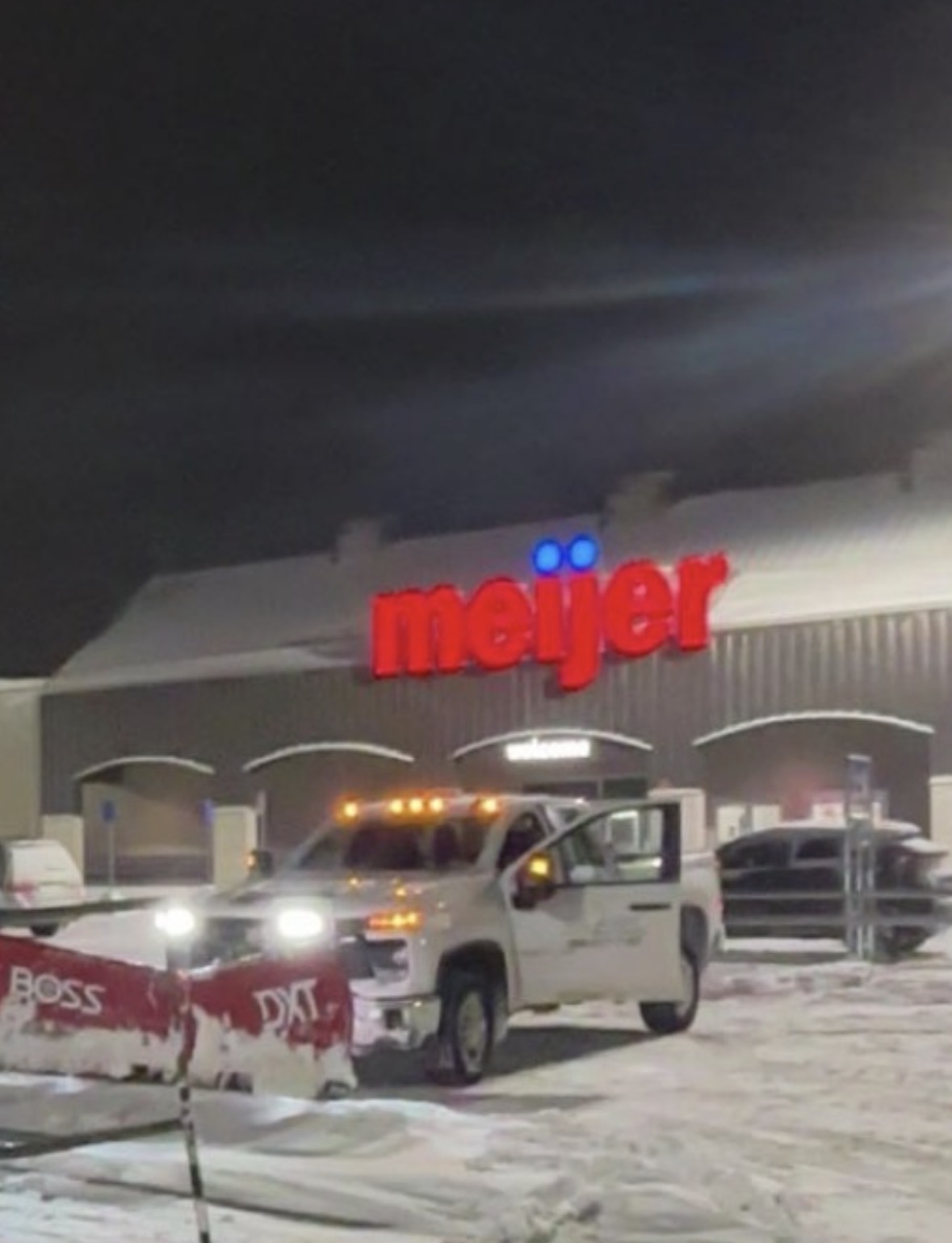 Swift Power & Soft Washing plow truck clearing a grocery store parking lot at night